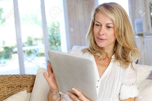 beautiful mature mature woman photo home beautiful using tablet goodluz electronic