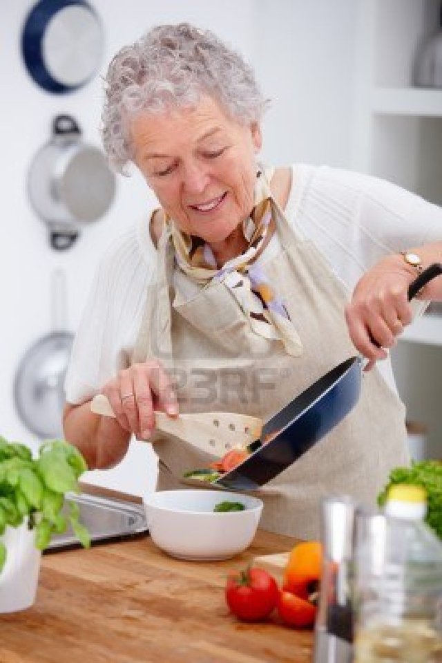 mature old mature woman old photo kitchen preparing logos food pan holding