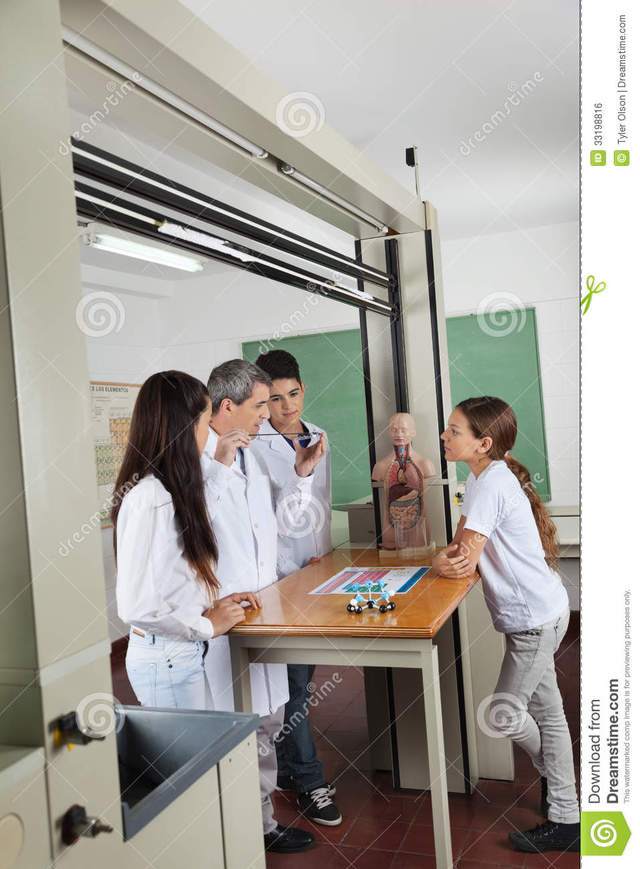 mature teacher mature male him teacher using student looking students computer experimenting lab desk classroom