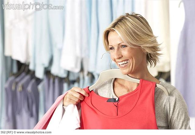 red mature mature woman blonde photo red clothes shop shopping smiling holding vest coathanger