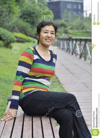 asian mature pics happy asian mature woman sitting bench outdoors stock photo