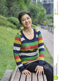 asian mature pics happy asian mature woman sitting bench outdoors stock photo