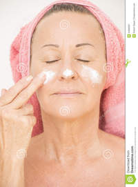 mature face pics woman putting cream face portrait attractive relaxed mature moisturizing smiling lotion finger cheek towel royalty free stock photography