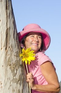 mature in sexy roboriginal portrait sexy mature woman wearing pink hat sunflower hugging tree park isolated blue photo