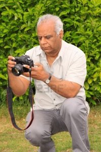 mature asian cabman mature asian photographer checking his camera settings photo