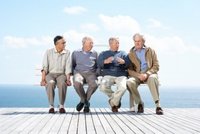 mature group logos portrait group male mature friends sitting together bench ocean outdoor photo