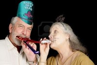 mature party lisafx mature couple year party hats blowing noise makers isolated black photo