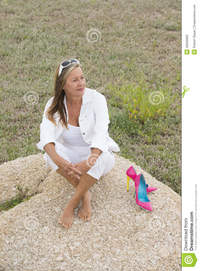 outdoor mature relaxed confident woman outdoor wth high heels portrait attractive mature sitting alone happy rock bare feet heel stock photo