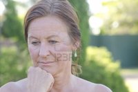 outdoor mature roboriginal outdoor portrait sad worried looking mature woman isolated blurred background photo