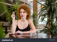 redhead mature stock photo thoughtful redhead woman curly hair smoking restaurant pic