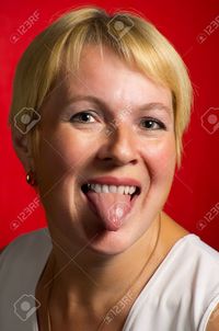 red mature shell mature woman showing tongue against red background stock photo