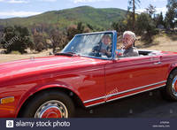 red mature comp npnk mature couple driving red convertible car along country road smiling stock photo