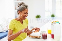 spreading mature preview mature woman eating breakfast spreading jam toast