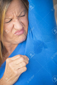 wet mature roboriginal portrait angry mature woman sweat perspiration under arm wet moisture spot blue shirt stock photo